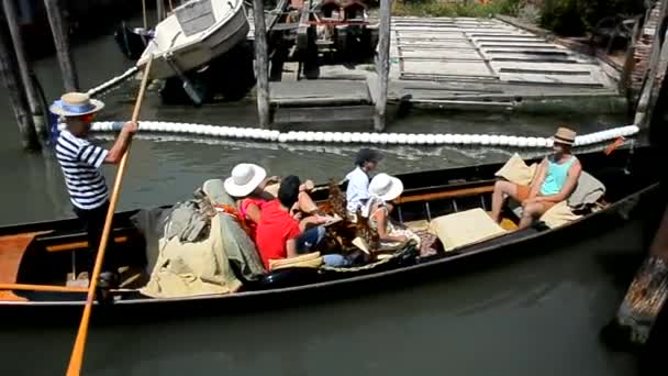 Turystów żagiel na gondola przez wąski kanał, gondolier pokazuje je miasta — Wideo stockowe