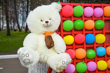 Beyaz oyuncak ayı ve parlak renkli toplar.