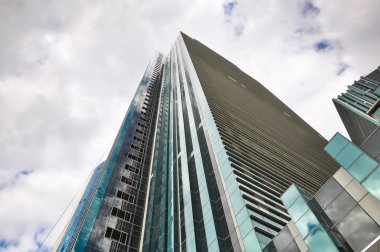 Bir arka plan bulutlu gökyüzü üzerinde uzun boylu office gökdelen