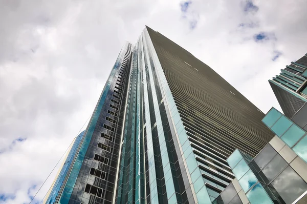 Bir arka plan bulutlu gökyüzü üzerinde uzun boylu office gökdelen