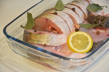 Bir cam tepsi içinde baharatlar ile dilimlenmiş balık yakın çekim