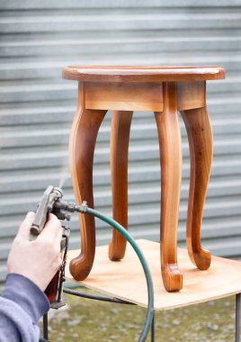 Carpenter is covering stool by lacquer clipart