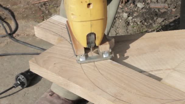Carpinteiro está cortando uma placa com fretsaw — Vídeo de Stock