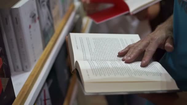 Homme choisir un livre dans un magasin — Video