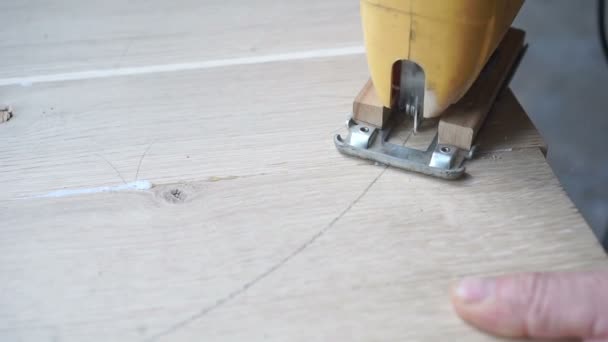 Carpenter coupe une planche avec scie à métaux 