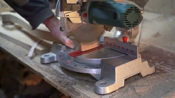 Плотник режет деревянный бар электропилой — стоковое видео