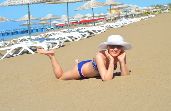 Lykkelig kvinne i bikini og hatt på en strand – stockfoto
