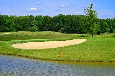 Yeşil golf sahası ve mavi gökyüzü