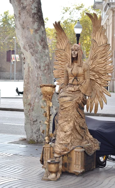 Estátua humana vestida de anjo dourado tocando em La Rambla — Fotografia de Stock