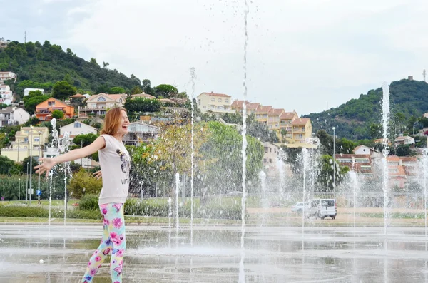 Salpicando agua de la fuente. Chica disfrutando de chorros de fuente — Foto de Stock
