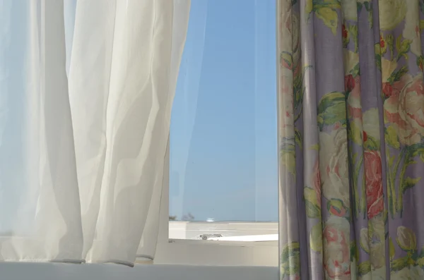Curtain with floral print on window against blue sky — Stock Photo, Image