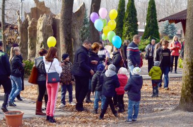 Çocuklar parkta balonlarla. Ebeveynler ve çocuklar açık havada renkli balonlarla