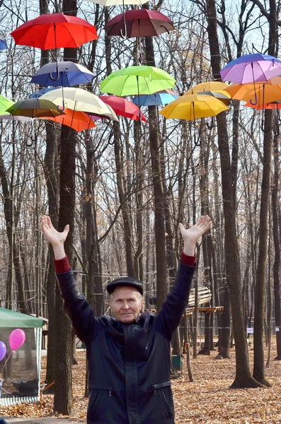 Uomo con in mano degli ombrelli luminosi. Concetto di libertà — Foto Stock