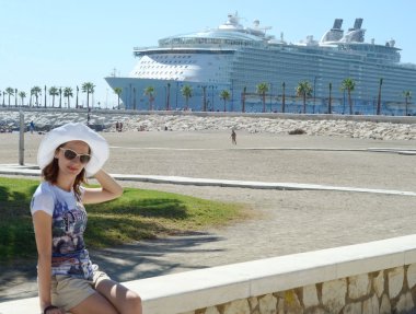 Güneşli bir günde çekici kız cruise gemi arka plan üzerinde bir plajda