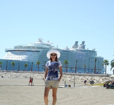 Güneşli bir günde çekici kız cruise gemi arka plan üzerinde bir plajda