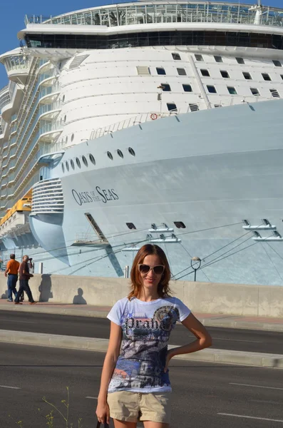 Отдыхающая молодая женщина с круизным кораблем на заднем плане — стоковое фото