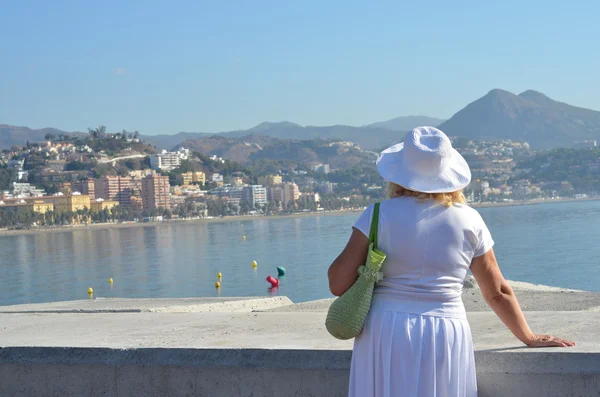 Volwassen vrouw genieten van de zomervakantie en kijken naar zee — Stockfoto