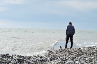 Denize bakarak iskelede duran adam