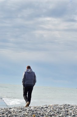 Denize bakarak iskelede duran adam