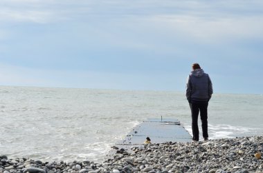 Denize bakarak iskelede duran adam