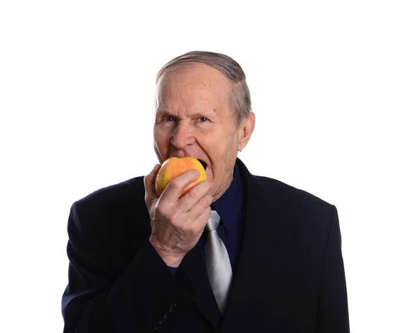 Homem idoso comendo maçã — Fotografia de Stock