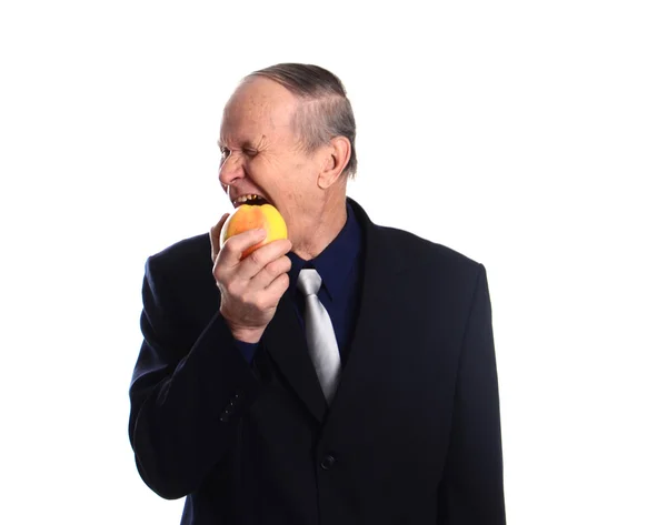 Старший чоловік їсть яблуко — стокове фото