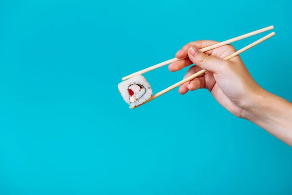 Mano Mujer Sostiene Tasty Sushi Roll Maki Con Palillos Madera —  Fotos de Stock