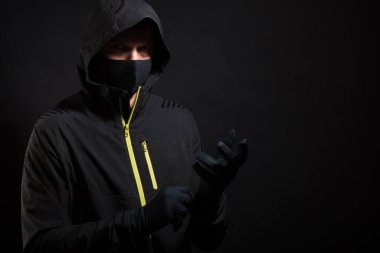 Maskeli adam eldiven takıyor. Soygun ya da hackleme hazırlığı