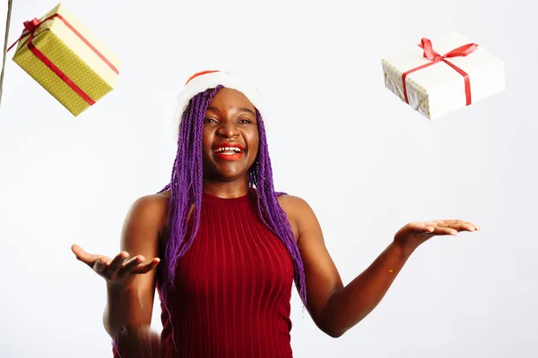 Krásná afro americká žena chytá padající dárky, dívá se na kameru a usmívá se, izolované na bílém pozadí — Stock fotografie