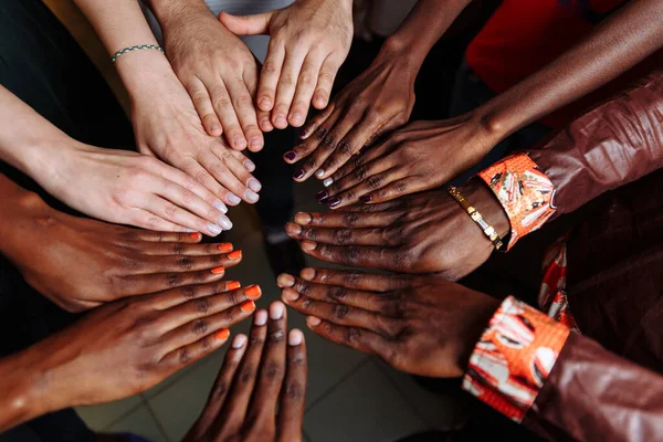Az afrikai latin-amerikai és európai emberek boldog csoportjának kezei, akik együtt maradnak a körben — Stock Fotó