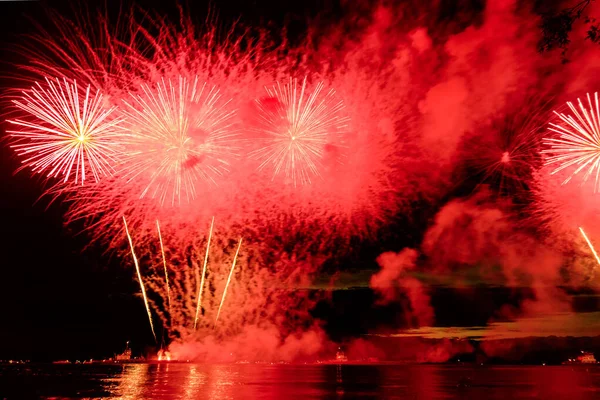 Holiday fireworks above water with reflection on the black sky background — Stock Photo, Image