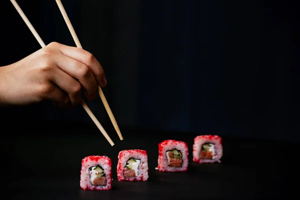 Mão Feminina Leva Pauzinhos Sushi Califórnia Rolos Com Pauzinhos Chineses — Fotografia de Stock