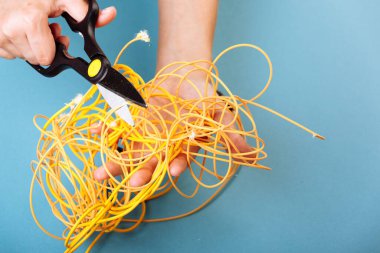 Optik fiberi makasla yok et. Mavi üzerine izole edilmiş.