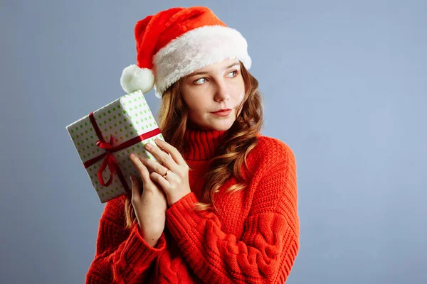 Happy European Santa Woman est surprise et tient une boîte cadeau pour Noël ou le Nouvel An. Isolé sur fond gris — Photo