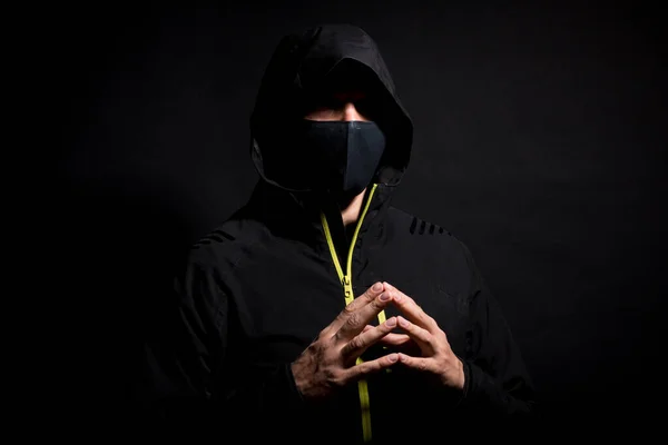 Retrato de hombre hacker en la capucha aislado sobre fondo negro — Foto de Stock