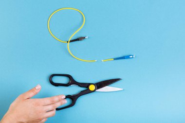 Optik fiberi makasla yok et. Mavi üzerine izole edilmiş..