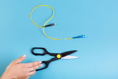 Optik fiberi makasla yok et. Mavi üzerine izole edilmiş..