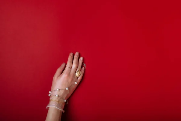 Fashion art hand woman in the glove protection against COVID-19 with Jewelry isolated on red background — Stock Photo, Image