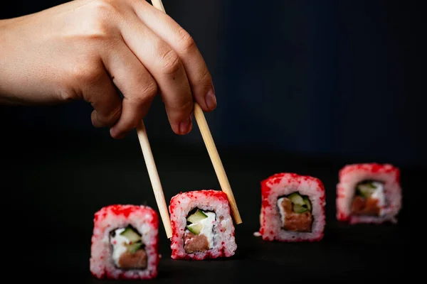 Mão Feminina Leva Pauzinhos Sushi Califórnia Rolos Com Pauzinhos Chineses — Fotografia de Stock