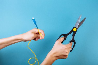 Optik fiberi makasla yok et. Mavi üzerine izole edilmiş..