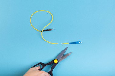 Optik SC fiberini makasla yok et. Mavi üzerine izole edilmiş..