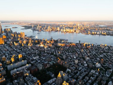 Manhattan şehir merkezindeki Hudson Nehri 'nin ve New Jersey' nin güneş doğarken çekilmiş fotoğrafı. Arka planda bulutlar var. New York, ABD.