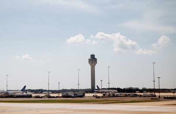 View of Washington Dulles airport terminal and parking lot under clear sky on a sunny day. g.