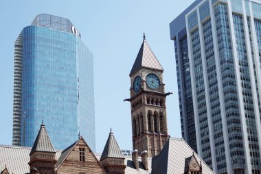Toronto şehir merkezindeki modern gökdelenler tarafından çerçevelenmiş tarihi belediye binası saat kulesi aydınlık bir günde. g.