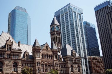 Toronto şehir merkezindeki modern gökdelenler tarafından çerçevelenmiş tarihi belediye binası saat kulesi aydınlık bir günde. g.