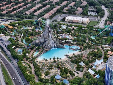 Yanardağ, havuzlar, slaytlar ve Orlando, Florida, ABD 'deki karayolu trafiği ile volkan körfezi su parkının hava görüntüsü. g.