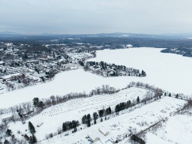 Donmuş gölü, mezarlığı, karlı evleri ve yolları olan Waterloo kasabasının kış manzarası, Quebec, Kanada. g.