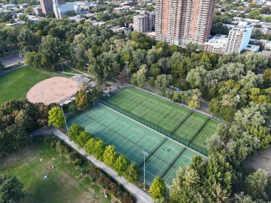 Parc La Fontaine 'deki tenis kortlarının havadan görünüşü, Montreal şehir parkı, yeşil ağaçlar ve spor yapan insanlar. g.
