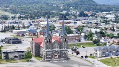 Quebec 'teki Saint Anne des Monts yakınlarındaki St. Ann Katolik Kilisesi' nin evleri ve dağları. g.