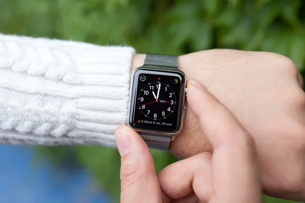 Ręką człowieka i Apple zegarek z czasem na ekranie — Zdjęcie stockowe